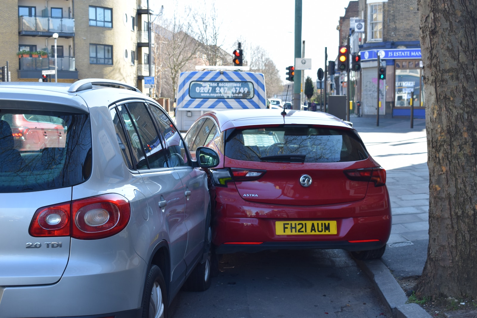 a red car is parked next to a silver car