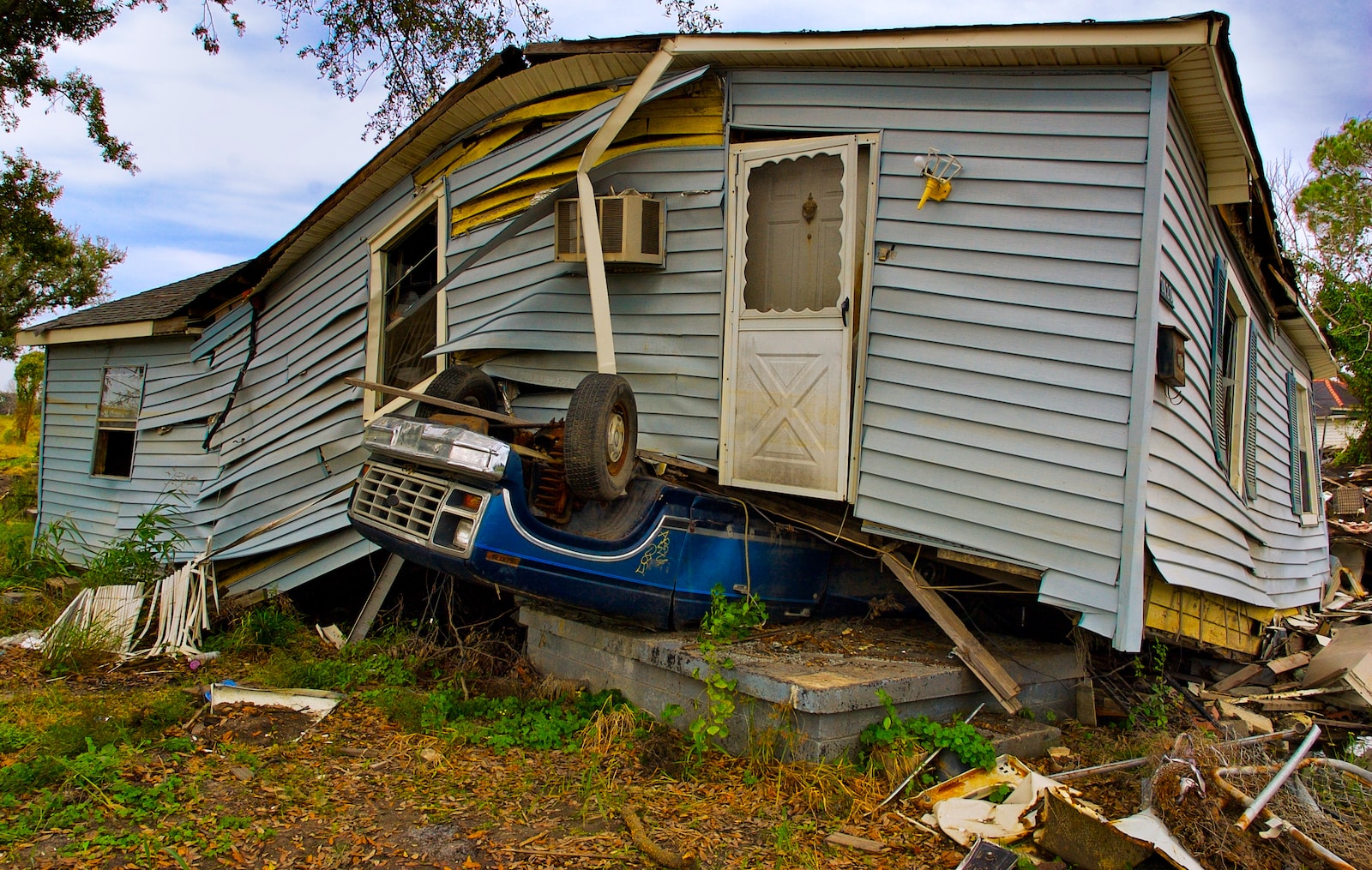 gray wrecked house & car by natural disasters